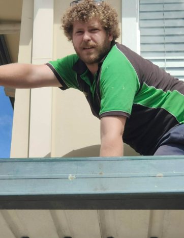 Nathan working on a balcony gutter, doing the trades work most builders sub out